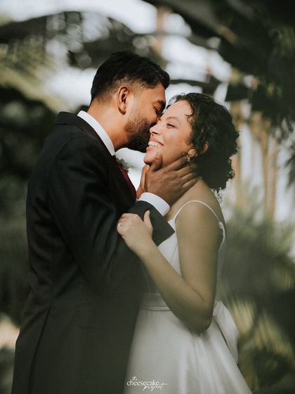 The groom whispering in his bride's ear, her smile says it all.