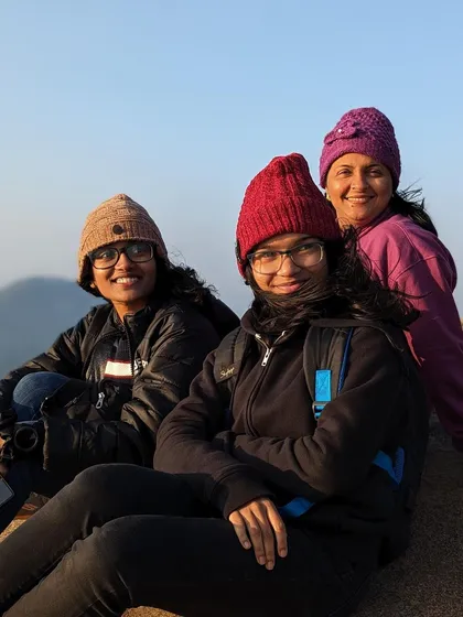Three friends in their winter hats, enjoying the cool morning at the top of Skandagiri.