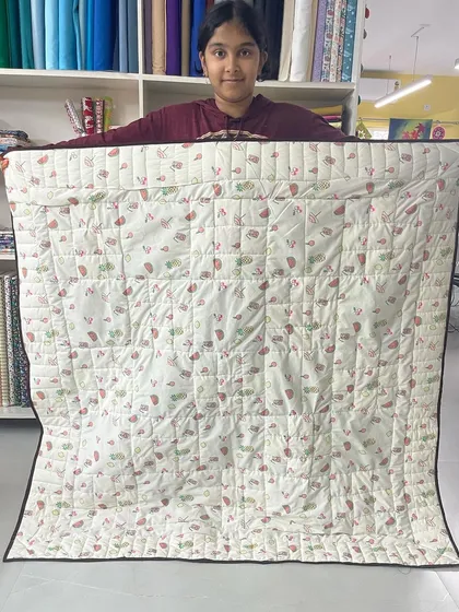 The back of a quilt made by a 12-year-old student, showing the simple, effective straight-line quilting she learned in her first project.