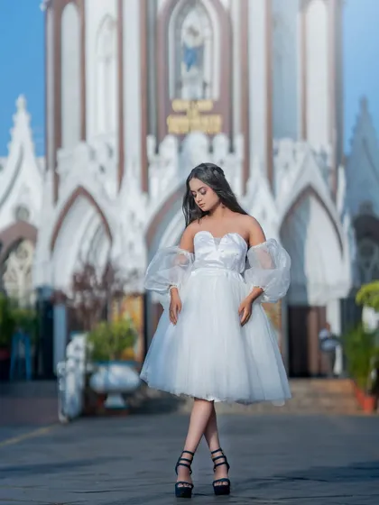 A full-length shot in front of a church, creating a beautiful and classic Christmas card feel.