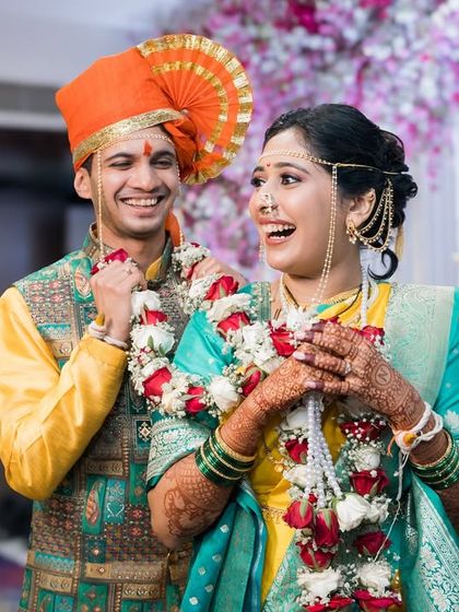 A joyful couple sharing a laugh after their garland exchange ceremony.