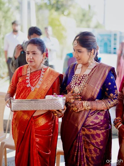 A heartwarming candid moment with her mother, both looking elegant in their traditional sarees.