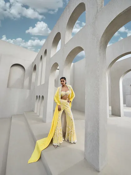 The yellow embroidered sharara set, where every thread catches the glow, refracting brilliance with each movement.