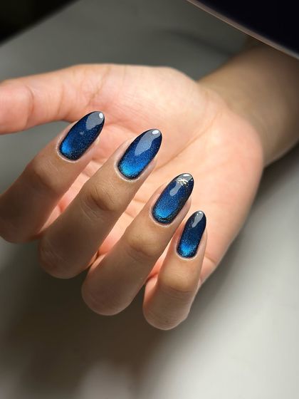 Cat-eye magic. A simple yet stunning set of deep blue cat-eye nails that look like drops of the ocean.
