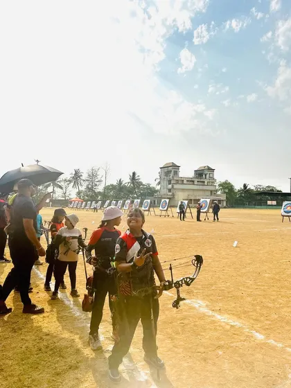 An archer gets ready on the shooting line at the Drona Cup, with targets set up in the distance.