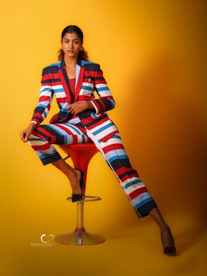 A powerful, wide-legged stance on the stool. This portrait exudes confidence and control, making a strong statement.