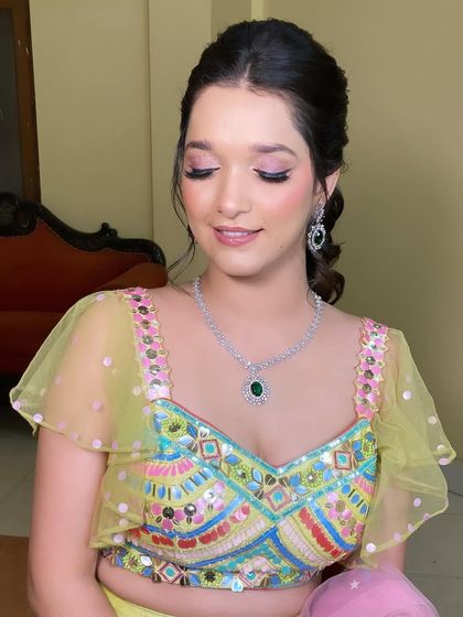 The complete look is so fresh and festive. The soft makeup and pretty ponytail hairstyle are perfect for a fun-filled mehndi celebration.