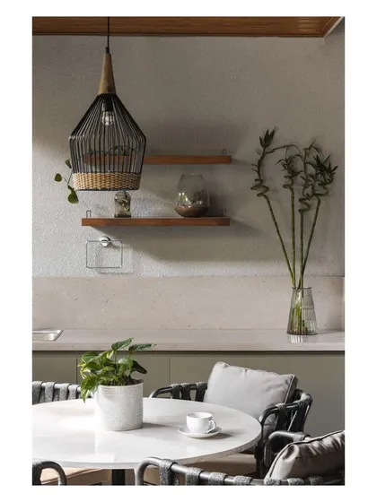 A detail of the outdoor pantry and dining area, showing the mix of concrete-finish countertops, wooden shelves, and a woven pendant light.