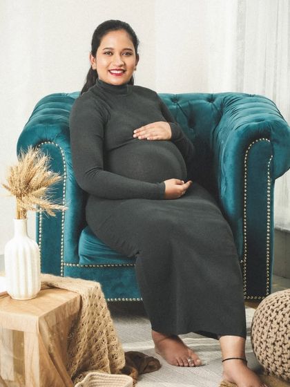 A classic and contented portrait of an expecting mother. Her gentle smile and the way she holds her bump show a quiet confidence and joy.