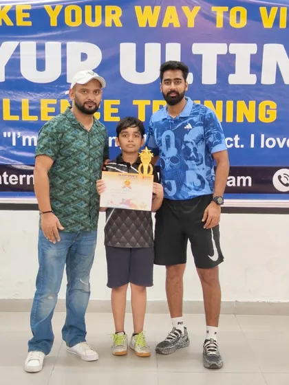 Our coaches stand proudly with a young winner at the SkyUp Open Tournament. This photo captures the supportive relationship between our coaches and players.