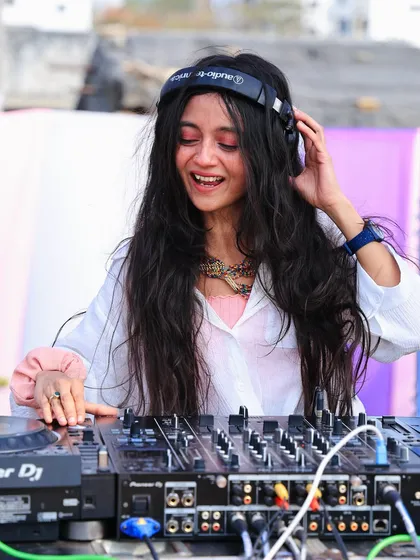 Adjusting my headphones during a daytime Holi set. Even in the middle of all the fun, I'm focused on delivering a flawless musical experience.
