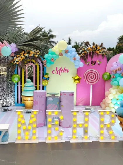 A grand outdoor Candyland setup with multiple backdrops, large props, and marquee letters, perfect for a large-scale celebration.