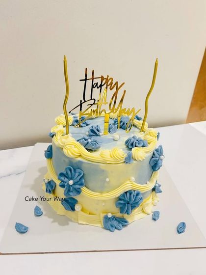 Buttercream dreams and birthday beams. A vintage-style cake in blue and yellow with delicate floral piping.