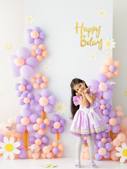 A shy, sweet pose amidst a sea of pastel balloons. Each birthday shoot is tailored to the child's personality, whether they are shy or outgoing.