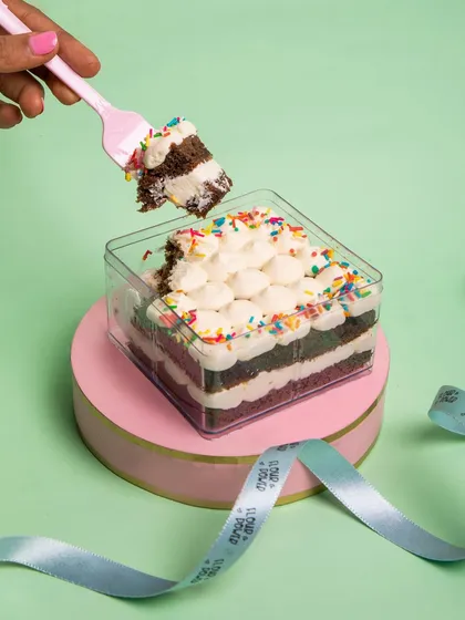 A classic vanilla buttercream cake tub with colorful sprinkles. It's a simple, joyful treat that's perfect for any day of the week.