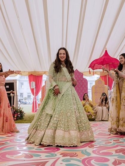A bride's mehendi performance with her bridesmaids. I choreographed this fun and colorful routine, using bright pink umbrellas as props to match the vibrant decor and festive mood of the London event.