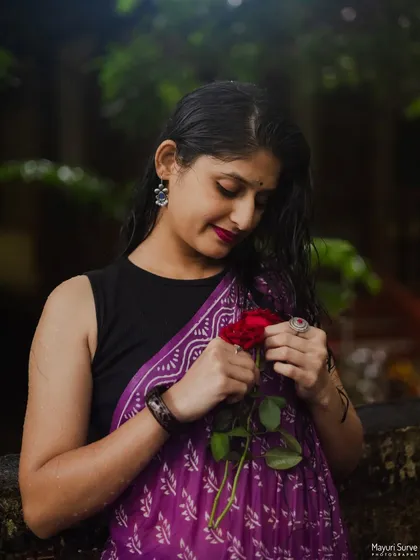 A close-up portrait with a single red rose. The model's gentle expression and the soft lighting create a romantic and intimate mood, perfect for capturing personal stories.