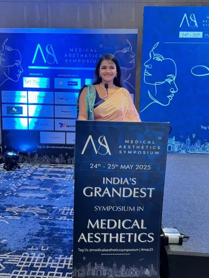 At the lectern for Day 1 of the Medical Aesthetics Symposium 2025, dressed in a traditional saree to bring a touch of elegance to the formal proceedings.