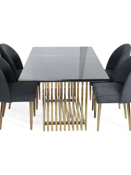 This elegant dining set features a table with a grey glass top and a base of vertical PVD gold slats. The curved dining chairs are upholstered in a matching suede grey fabric for a cohesive look.