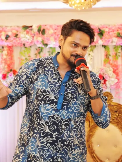 A candid shot of me hosting a daytime event. Dressed in a festive kurta, I'm ready to get the party started with my mic in hand.