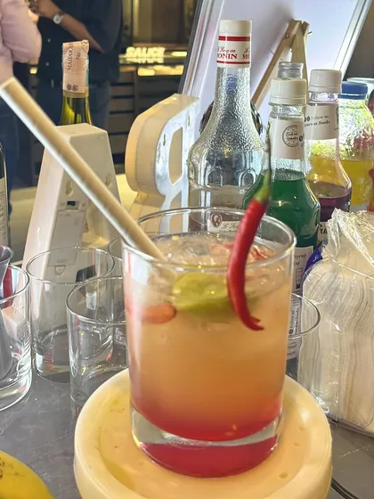 A spicy, layered cocktail with a red chili garnish. We love creating drinks that are bold and full of character.