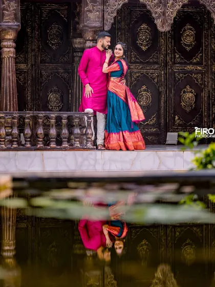 I love playing with creative compositions like this reflection shot. It adds an artistic, symmetrical element to this beautiful portrait of a couple in traditional attire, set against a grand backdrop.