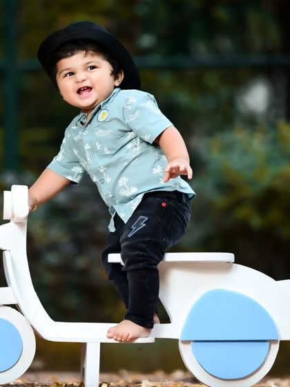 A full shot of the baby boy on his scooter, capturing his excitement.