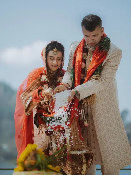 A close-up of a wedding ritual where the couple makes an offering together.