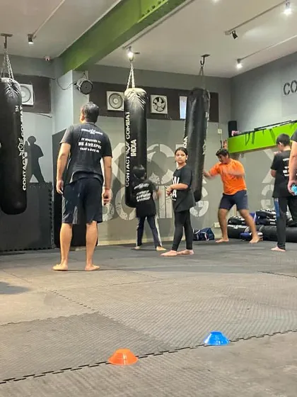 An instructor guides the kids' class through drills. Our goal is to make learning self-defense an engaging and empowering experience for them.