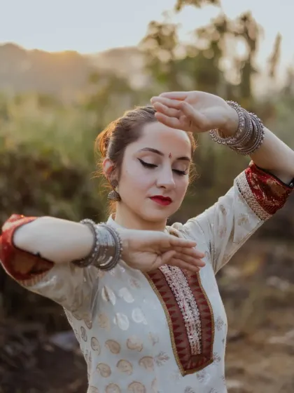 A close-up focusing on the intricate hand gestures, or 'mudras', of Kathak dance. This shot highlights the dancer's expressive hands and traditional silver bangles.