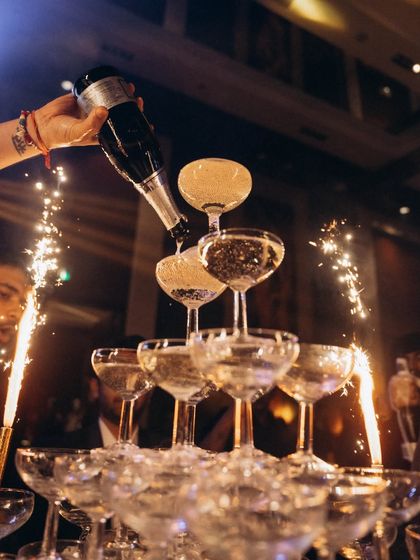 The classic champagne tower, complete with sparklers. This shot captures a moment of glamour, excitement, and celebration at the wedding reception.