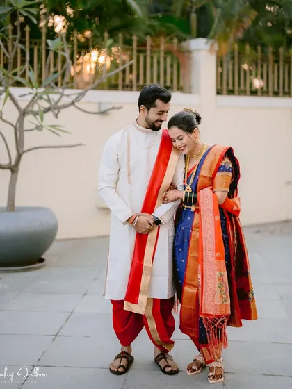 A shy, downward glance from Sayali as she walks with Gaurav. This image beautifully captures the blend of tradition and romance on their wedding day in classic Peshwai attire.