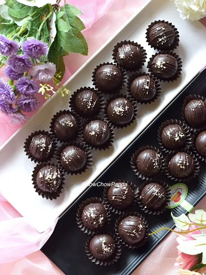 The dark chocolate cake pops arranged on black and white platters, ready to be served at an event.