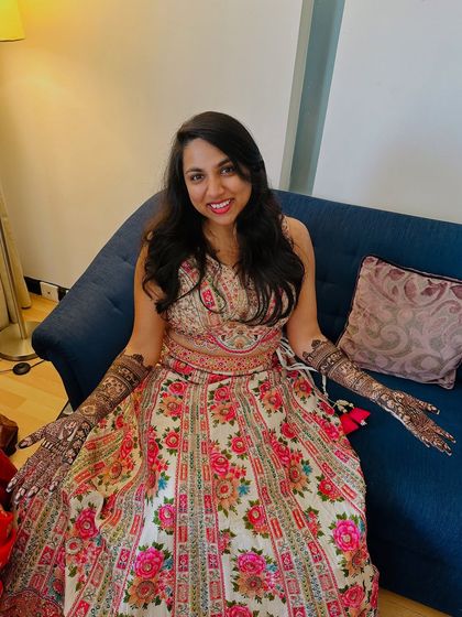 A beautiful bride in a floral lehenga, ready for her celebrations with her full bridal mehndi.