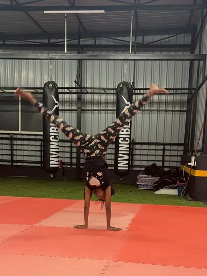 This student is mastering her handstand straddle, showing great balance and control.