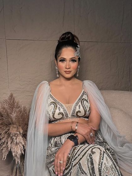 One of my all-time favorite looks. This client is wearing a unique white and gold outfit, and I complemented it with a sophisticated high bun and glamorous makeup.