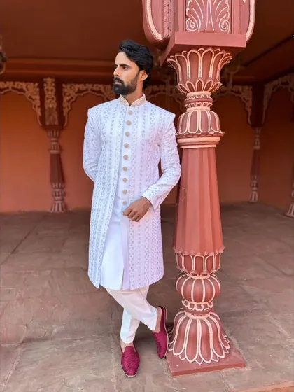 This full-length shot shows our white sherwani paired with contrasting maroon loafers, a great way to add a pop of color to a monochrome look.
