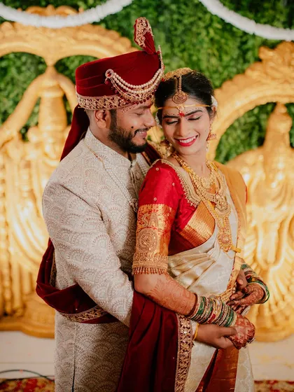 A classic and elegant portrait of the couple in their traditional wedding attire, sharing a happy and intimate moment.