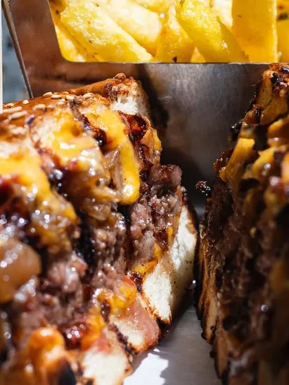 A cross-section of a juicy, cheesy burger from Saltbae's burger joint, showing all the delicious layers inside.