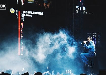King in a quiet, emotional moment on stage, seated amidst a cloud of smoke. I create space for both high-energy bangers and intimate performances.