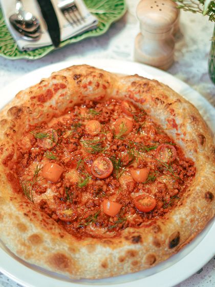A hearty and flavorful pizza topped with minced meat and sweet cherry tomatoes. The rich toppings are balanced by our light and airy Napoletana crust.