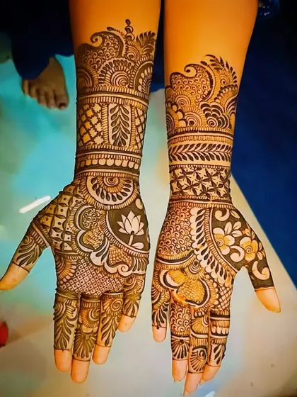 A complex and beautiful design featuring a lotus on one palm and a heart on the other, surrounded by dense traditional patterns.