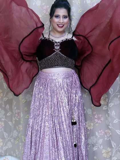 A dramatic pose showing off the full lehenga with its flowing sleeves. The makeup is bold enough to stand out and complete the powerful look.