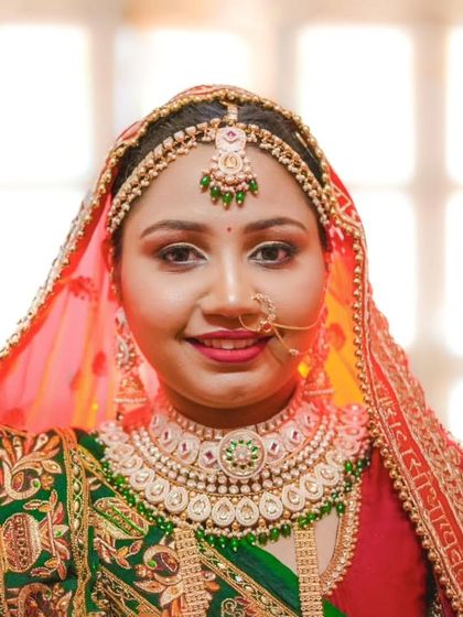 A beautiful close-up portrait of a bride in her traditional Gujarati wedding attire, highlighting her intricate jewelry and radiant smile.