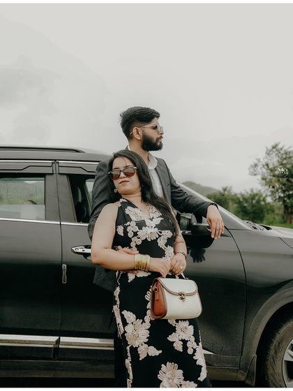 Posing with their Kia Seltos in a beautiful green landscape. This shot has a cool, confident vibe, perfect for a couple that loves road trips and style.