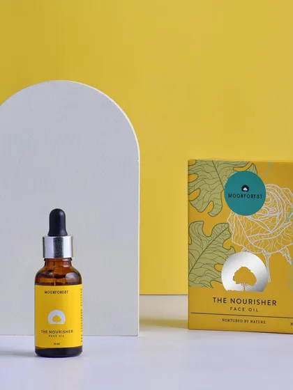 A styled product shot of Moon Forest's face oil, using a white arch prop for a modern, architectural feel. The color contrast makes the product pop.