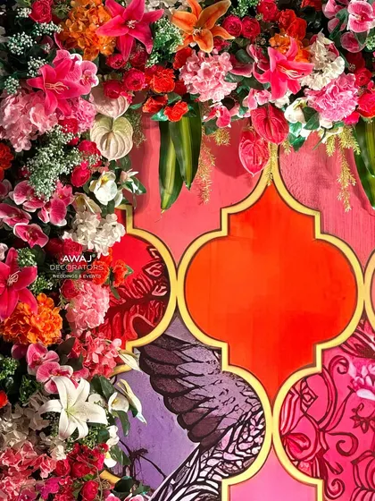 A detailed close-up of the floral frame, featuring a mix of roses, lilies, and anthuriums in a riot of color.