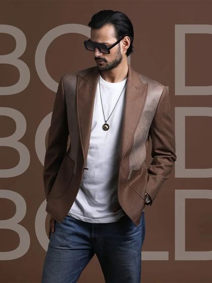 A brown blazer with satin lapel details, paired with a simple white t-shirt and jeans. This is how you make a bold statement with a single, well-crafted jacket.