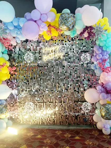 A full view of the shimmering sequin wall and pastel balloon arch. The "Happy Birthday" neon sign adds a modern touch to this vibrant and cheerful photo booth setup.