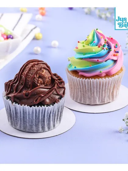 Two of our most requested cupcakes side-by-side. The Overload cupcake with a Ferrero Rocher on top, and the whimsical rainbow Unicorn cupcake, showing the range from decadent to playful.
